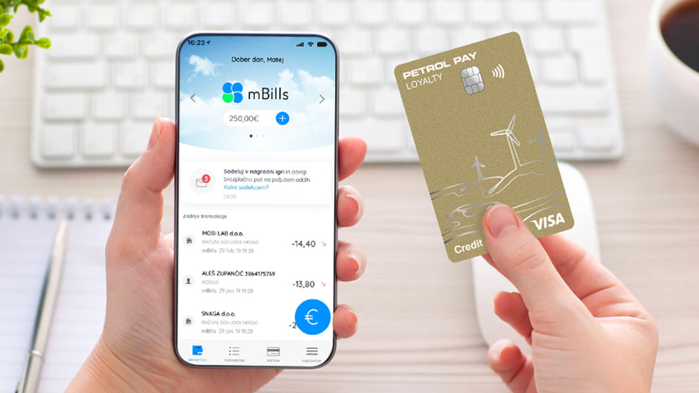 Oseba v rokah drži pametni telefon z odprto aplikacijo mBills in plačilna kartica Petrol Pay Loyalty.