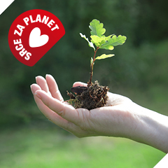Dlan drži majhno sadiko drevesa z zemljo, v levem zgornjem kotu je znak »Srce za planet«.