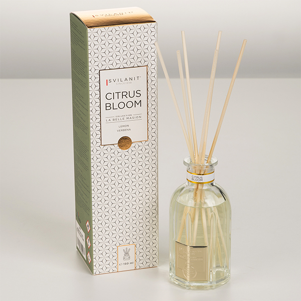 Na sliki je Aroma difuzor Svilanit, Citrus Bloom, 150 ml - Elegantna steklenička in naravne paličice. Ozadje je v nevtralni beli barvi.